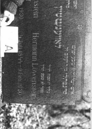 Grabstein 27 (Index: 100116543) Material: Granit Zustand: gut Maße HxBxT: 108x97x12 cm Beschreibung: Stele, breit, Sockel, giebelartiger Abschluß mit Voluten zu beiden Seiten Besonderheit: Doppelgrab für Eheleute: Grabstein 27A