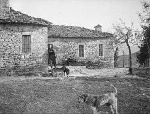 Steinhaus : Aufnahme eines Mannes mit Hunden vor einem Steinhaus