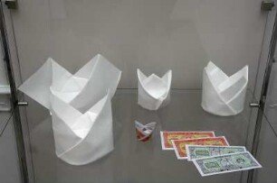 Serviettenfaltkunst. Dresden-Pillnitz, Kunstgewerbemuseum. 2007.06.30-10.31. Standvitrine mit gefalteten Servietten von J. Sallas
