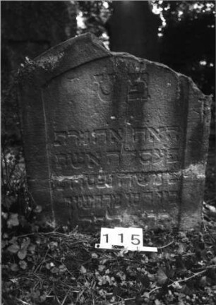 Grabstein 115 (Index: 100085512) Maße HxBxT: 80x70x8 cm Beschreibung: Stele, Segmentbogenabschluß, Schriftfeld eingetieft auf Vorderseite: Grabstein 115
