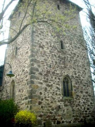 Evangelische Kirche - Kirchturm (spätromanisch gegründet-13 Jhd) von Ostsüdosten mit Schlitzfenstern sowie Werksteinen im Mauersteinverband über Kirchhof