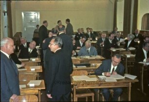 Kreistagssitzung: Kreisberufsschule [Bad Oldesloe]: Grabauer Straße / Ecke Lorentzenstraße: Aula: Kreistagsmitglieder im Gespräch und an Schulbänken