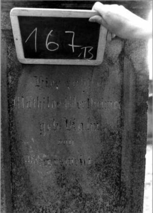 Grabstein 167 (Index: 100111340) Material: Sandstein Zustand: leicht verwittert Maße HxBxT: 197x60x46 cm Beschreibung: Stele, profilierter Sockel, Abdeckplatte mit Volutenaufsatz, rechteckige Schriftfelder eingetieft Symbolik: Blüten, Voluten: Grabstein 167B