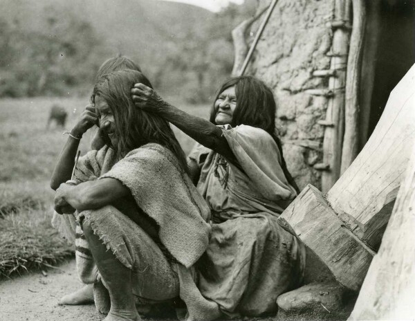 Alte Arhuaco Indianerin, ihren Sohn(?) lausend