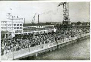 Menschenmenge an der Columbuskaje in Bremerhaven verabschiedet den Hochseepassagierdampfer "Bremen" zu seiner "Jungfernfahrt" am 16. Juli 1929