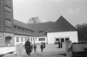 Gruppe vor Gebäude : Eine Gruppe in Uniform vor einem Gebäude mit einem verschindelten Turm
