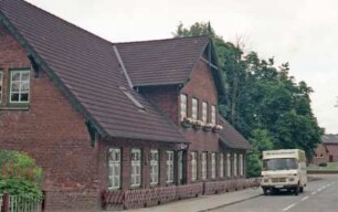 Dorfstraße: Alte Schule: Teilansicht: traufständige Straßenfront: Zwerchgiebel, Eingangstür, Butzenscheiben
