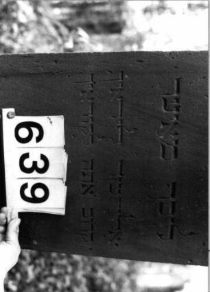 Grabstein 639 (Index: 99802941) Material: Sandstein Zustand: Maßwerk gebrochen/hinten stark verwitt. Maße HxBxT: 183x50x37 cm Beschreibung: Sock/St. m. verdacht. Giebel/Inschriftenfeld m. Spitzbogen und Maßwerk Symbolik: Maßwerk Besonderheit: Wortspiel mit dem Namen Elieser: Grabstein 639 (Detailaufnahme 2)