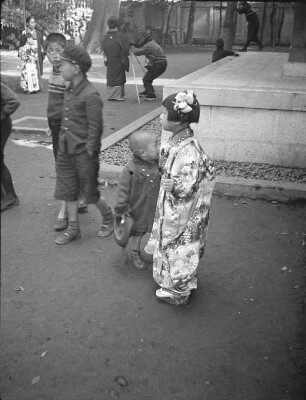 Kashima-Schrein, wahrscheinlich in Shinagawa, während des Shichi-go-san-Festes im November : Kashima-Schrein, wahrscheinlich in Shinagawa, während des Shichi-go-san-Festes im November. Kindergruppe mit kleinem Mädchen in festlichem Kimono