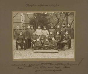 13 Kadetten und ihre sechs Lehrer des Obertertia-Kurses 1908/09 teils stehend, teils sitzend im Garten der Kadettenanstalt Karlsruhe