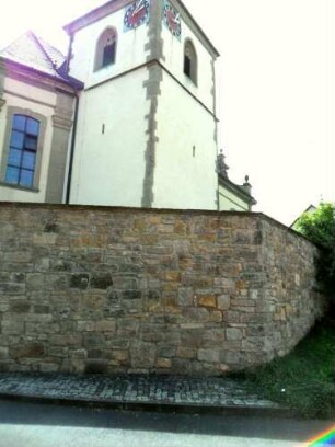 Ansicht von Nordosten mit Kirche (Kirchturm im Kern Gotisch) über Kirchhofmauer (Wehrgang mit Steinbrüstung im 18 Jh abgetragen)