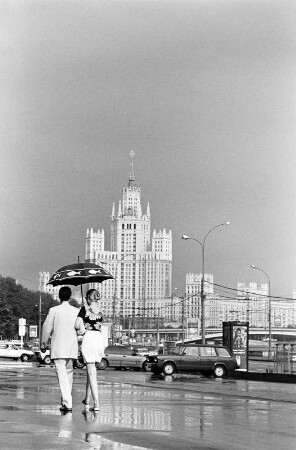 Straßenszene mit einem Paar mit Regenschirm an der Kotelnitscheskaja-Uferstraße, vor der Lomonossow-Universität, Moskau : Straßenszene, Moskau