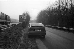 Vorstellung des Opel Kadett GSi 16 V: Rückansicht mit Heckspoiler: auf Autobahnabfahrt zu Raststätte, links Autobahn, Lkw