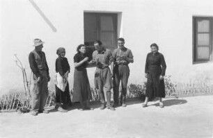 Kolonisten vor einem Haus : Eine Gruppe von Personen vor einem Gebäude