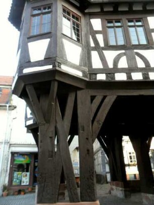 Stadtbild-Rathaus-Ansicht von Süden im Südwesten mit offener Erdgeschoßhalle auf Holzstützen sowie Eckerker im Obergeschoß mit Fachwerkstruktur (verzapft) im Detail