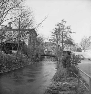 Trave: Stadtarm: rechts Parkfläche mit Pkw: links ehemaliges Fabrikgebäude Richtung Schultwiete: hinten Fußgängerbrücke