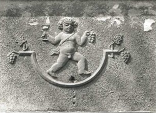 Dresden-Pieschen, Hubertusstraße 53/57. Wohnhauszeile (um 1928). Figürlicher Schmuck. Putto mit Traube und Kelch (Nr. 57, 1. Obergeschoss)