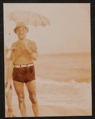 Heinrich Zimmer in Badehose und Sonnenschirm am Meer