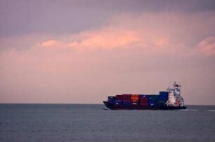 Deutschland. Niedersachsen. Cuxhaven. Container Schiff im Abendlicht