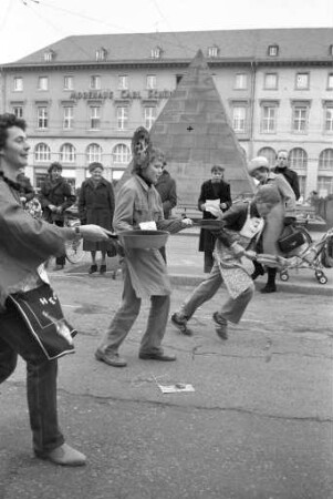 Deutsch-englischer Freundeskreis Karlsruhe. Pfannkuchen-Rennen "pan-cake-race" am schmutzigen Donnerstag auf dem Karlsruher Marktplatz