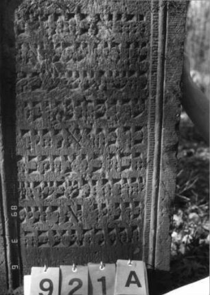 Grabstein 921 (Index: 99753203) Material: Sandstein Zustand: leicht verwittert Maße HxBxT: 128x54x10 cm Beschreibung: Stele, geschwungen eingezogener Rundbogenabschluß, Schriftfeld eingetieft: Grabstein 921A