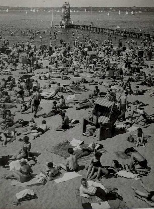 Berlin-Steglitz. Menschenmassen sonnen sich am Strand des Freibades Wannsee. Im Hintergrund der Sprungturm
