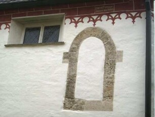 Evangelische Kirche-Langhaus über Traufseite Nord im Nordwesten-vermauertes Rundbogenfenster der Romanischen Vorgängerkirche-darüber erneuerte Farbigkeit mit Bauinschrift -Renoviert 1953