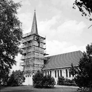 Evangelische Kirche St Johannis: Renovierung des Turms: Verkleidung mit Kupferplatten: Blick von Süden auf eingerüsteten Turm und Kirchenschiff: rechts auf Gerüst Arbeiter: davor Bäume