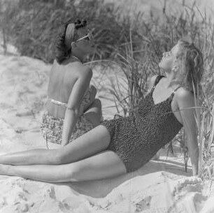 Elisabeth Gremmler (links) und eine Freundin liegen in Badebekleidung am Strand