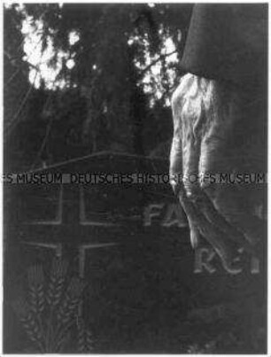 Hand vor Grabstein (Altersgruppe 18-21)