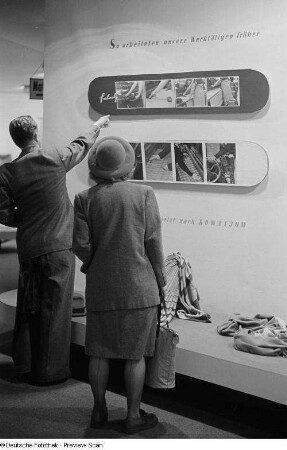 Fachbesucher an einem Messestand mit Stoffen