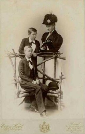 Familienbild, drei Personen: Kaiserin Auguste Victoria, Königin von Preußen, neben ihr stehend Kronprinz Wilhelm von Preußen, davor sitzend Prinz Eitel Friedrich von Preußen