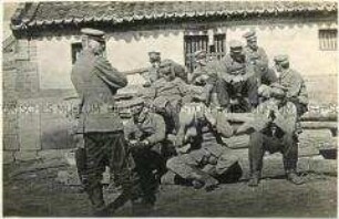 Gruppenaufnahme von wartenden Kriegsgefangenen im Lager Bando