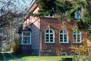 Struhbarg 12: giebelständiges Wohnhaus aus Backstein mit umlaufendem Gesims: Straßenfront mit Rundbogen-Sprossenfenstern, Teilansicht: Traufseite mit Auslucht, Altan, Rankgitter: links Plattenweg
