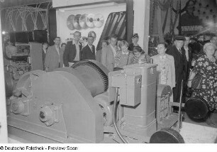 Besucher der Technischen Messe 1953 an Ständen mit Sägeblättern sowie einer Werkzeugmaschine