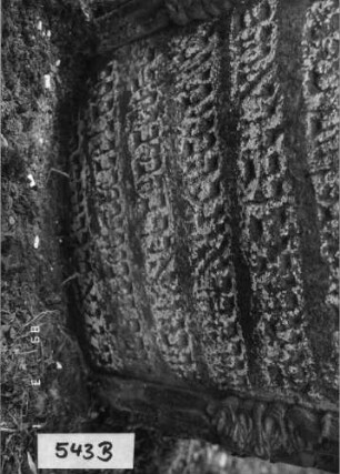Grabstein 543 (Index: 99753000) Material: Sandstein Zustand: stark abgeblätt/verwitt. mit groß. Textver Maße HxBxT: 123x67x14 cm Beschreibung: Stele, in Voluten auslaufender Rundbogenabschluß, Schriftfeld eingetieft Symbolik: Muschel, Voluten: Grabstein 543B