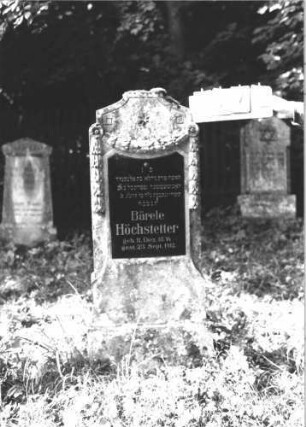 Grabstein 117 (Index: 100106420) Material: Sandstein, Schriftplatte Glas Zustand: leicht verwittert Maße HxBxT: 128x47x18 cm Beschreibung: Stele, Abschluß Sonderform, Schriftplatte Sonderform, Feston, Sockel Symbolik: Feston: Grabstein 117