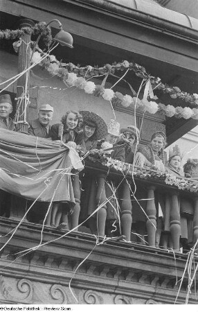 Karnevalsteilnehmer auf dem Balkon des Alten Rathauses