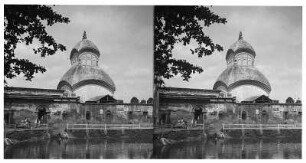 Kalkutta (Indien). Blick über ein Wasserbecken zu einem Tempel mit zweifach gestuftem kuppelartigem Dachbau