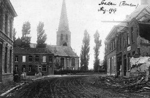 Staden (Flandern) [Bild einer Straße, die an einem zerstörten Haus und einer Kirche vorbei führt]