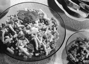 Krafts Rezeptaufnahmen. Große und kleine Schüssel mit Nudel-Gemüse-Salat, daneben ein Teller mit Brot