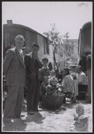 Kinderreiche Roma-Familie zwischen zwei Pferdewägen