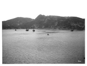 Hongkong. Blick über Bucht mit Dschunken gegen Victoria-Peak (?)