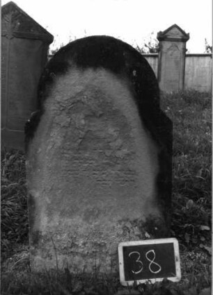 Grabstein 38 (Index: 99936949) Material: Sandstein Zustand: völlig verwittert Maße HxBxT: 105x60x16 cm Beschreibung: Stele, schräg eingezogener Rundbogenabschluß: Grabstein 38