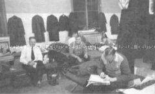 Selbstversenkung des Hochseepassagierdampfers "Columbus" am 19. Dezember 1939, Besatzungsangehörige im Internierungslager auf Ellis Island, auf Feldbetten sitzend, lesend, Briefe schreibend