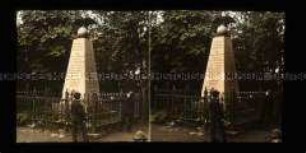 Drei Jungen vor einem Kriegerdenkmal