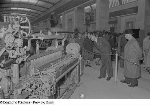 Besucher an einer Produktionsmaschine im Sowjetischen Pavillon