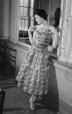 Modeaufnahmen, Frau im eleganten Kleid vor einem Spiegel