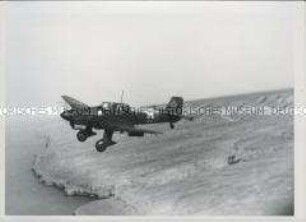 Eine Ju 87 Stuka im Flug über der nordafrikanischen Küste