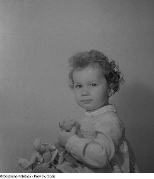 Porträt eines kleinen Mädchens mit Puppe und Teddybär